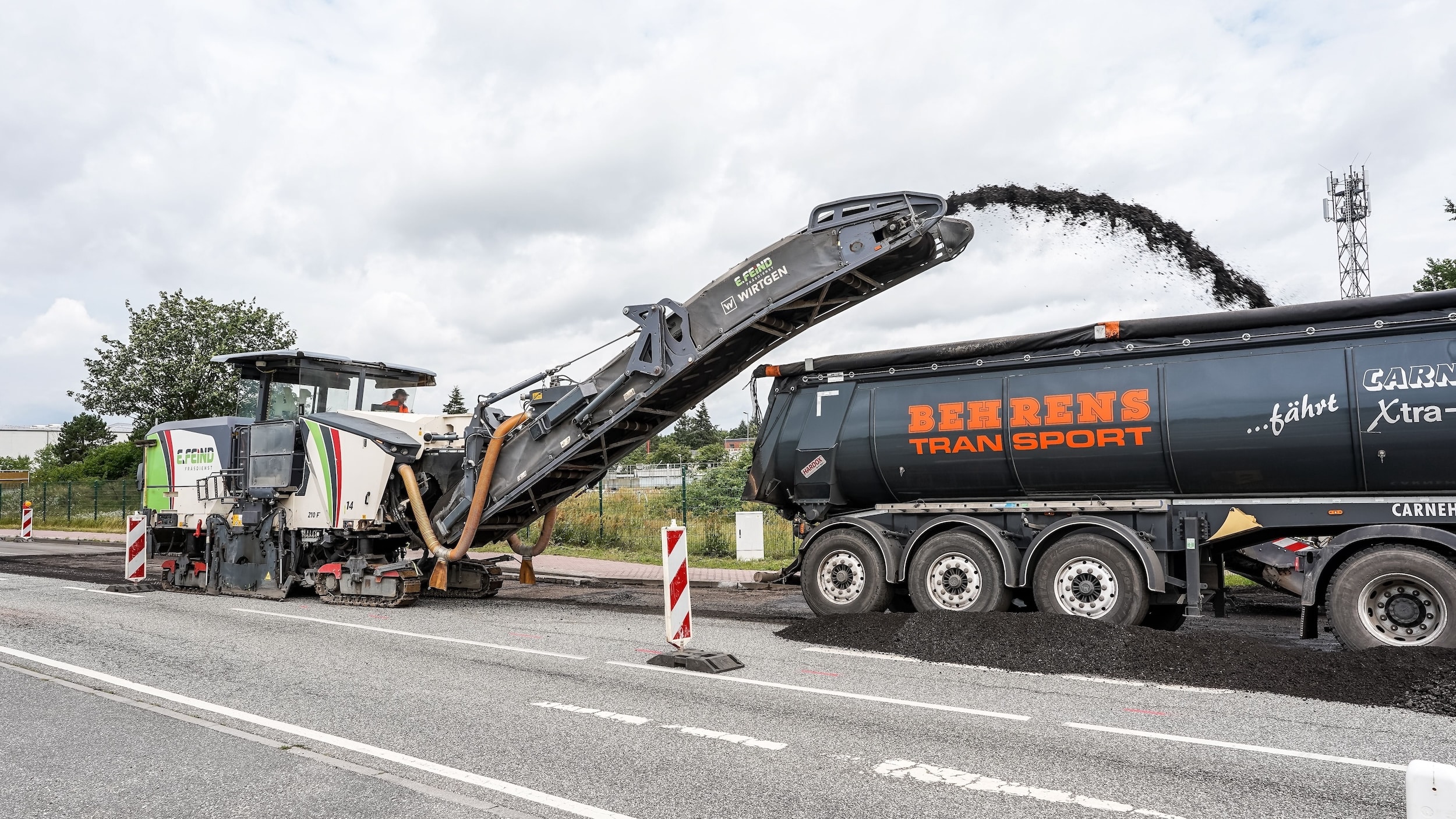 Ein Baustellenfahrzeug fräst die Straße auf, Gegenstand einer Aufbruchgenehmigung.